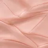 A close-up, abstract view of a textured, peachy-pink substance, possibly a cosmetic product like highlighter or foundation, showing smooth, flowing curves and subtle shimmer. Voir les images du produit
