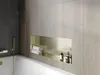 A modern bathroom with a bathtub and a built-in shelf. Voir les images du produit