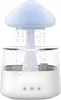 A white humidifier with a mushroom-shaped top that emits water droplets, resembling rain. The humidifier has a clear water tank and three control buttons at the base. Voir les images du produit