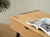 A close-up of a wooden desk with a magazine on it. Produktbild-Vorschau