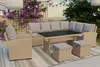 An outdoor patio setting with a rattan-effect lounge furniture set, including a sectional sofa, coffee table, armchair, and ottomans, surrounded by plants and string lights. Náhľad obrázku produktu
