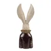 A decorative figurine of a rabbit's head and ears emerging from a dark brown garment with a ruffled collar. Produktbild-Vorschau