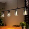 A dining table with a pendant light fixture hanging above it. Anteprima dell’immagine prodotto