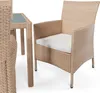A close-up view of a beige rattan chair with a white cushion, next to a table with a glass top. Náhled obrázku produktu