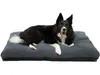 A black and white dog lying on a dark gray pet bed. Produktbild-Vorschau