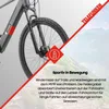 A close-up of an electric bicycle's front wheel and fork, with a mountainous landscape in the background. Produktbild-Vorschau