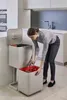 A woman is sorting waste in a modern kitchen. Podgląd zdjęcia produktu