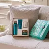 A gift set of Rituals Karma products is displayed on a textured couch next to a decorative gift box. Anteprima dell’immagine prodotto