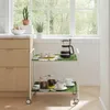 A kitchen scene with a serving cart next to cabinets and a window. Produktbild-Vorschau