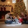 A family is gathered around illuminated Christmas gift decorations in front of a fireplace and a Christmas tree. Podgląd zdjęcia produktu