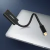 A black UGREEN adapter with a flexible cable is placed on a silver laptop. Voir les images du produit
