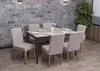 A dining set with chairs around a table in a room with a stone wall. Podgląd zdjęcia produktu