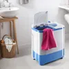 A mini washing machine with a pink towel draped over it, placed in a bathroom setting next to a sink and laundry basket. Produktbild-Vorschau