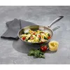 A stainless steel frying pan filled with pasta, tomatoes, and spinach, placed on a gray surface next to a folded gray towel, a tomato, spinach leaves, and a nest of pasta. Podgląd zdjęcia produktu