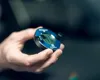 A hand holding a blue electronic parking disc. Náhľad obrázku produktu