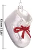 A white glass Christmas ornament shaped like a baby shoe with a red glitter bow and a measurement scale on the left. Voir les images du produit