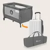 A travel crib is shown next to a suitcase and a carrying bag, with an arrow indicating it can be packed into the suitcase. Produktbild-Vorschau
