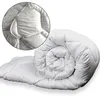 A white duvet is rolled up and partially unrolled on a white background. A circular inset shows a close-up of the duvet's stitching and texture. Produktbild-Vorschau