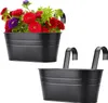 Two black hanging planters, one filled with colorful flowers. Produktbild-Vorschau