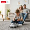 A family is playing with a remote-controlled car in a living room. Podgląd zdjęcia produktu