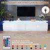 A white TV stand with LED lights and a remote control shown in the foreground. Anteprima dell’immagine prodotto
