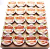 A collection of individual pudding cups arranged on a wooden surface. Produktbild-Vorschau