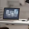 A laptop displaying a 3D architectural model of buildings, connected to a Belkin adapter on a desk. Produktbild-Vorschau