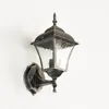 A vintage-style outdoor wall lamp mounted on a white wall. Produktbild-Vorschau