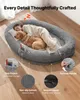 A woman and a dog sleeping on a large, plush dog bed. Voir les images du produit