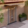 A modern entryway with a brick wall, a glass door, and a black polycarbonate awning. Anteprima dell’immagine prodotto