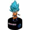 A figurine of Goku from Dragon Ball Z standing on a black alarm clock base. Voir les images du produit