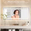 A woman applying cream to her face in front of a lighted bathroom mirror. Náhľad obrázku produktu