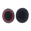 Two black ear pads for headphones are shown against a white background. One ear pad is shown from the side with its adhesive backing visible, and the other is shown from the front. Náhled obrázku produktu