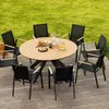 An outdoor dining set with a round wooden table and eight black chairs on a wooden deck, with a grassy lawn in the background. Produktbild-Vorschau