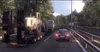 A truck transports a large piece of construction equipment on a highway. Produktbild-Vorschau