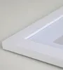 A close-up, angled view of a white picture frame with a white matting. Produktbild-Vorschau