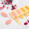 A yellow popsicle mold with partially filled cavities and two finished popsicles on a white surface with scattered berries and ice cubes. Produktbild-Vorschau