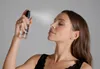 A woman is spraying a facial mist on her face. Produktbild-Vorschau
