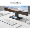 A minimalist desk setup featuring a monitor, keyboard, mouse, and a small alarm clock. Produktbild-Vorschau