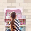 A young girl is playing with a dollhouse. Produktbild-Vorschau