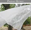 A white lace curtain is blowing in the wind, with trees and rocks in the background. Produktbild-Vorschau