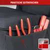 Close-up of a black fabric organizer with red tools in pockets, with a red banner at the top. Produktbild-Vorschau
