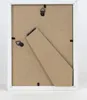 The back of a white picture frame with a brown backing board and a stand. Produktbild-Vorschau