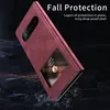 A red phone case is shown at an angle, with a dark, textured background. There are some scattered particles around the base of the case, suggesting it is falling or has fallen. Produktbild-Vorschau
