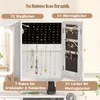 A jewelry cabinet with various compartments for rings, earrings, bracelets, and necklaces, displayed on a white surface with a blurred background. Voir les images du produit