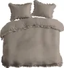 A taupe duvet cover and two pillowcases with ruffles, laid out on a white background. Produktbild-Vorschau