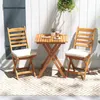 A wooden bistro set with two chairs and a table on a patio with a patterned rug. Anteprima dell’immagine prodotto