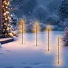 Outdoor winter scene with decorative spiral Christmas trees illuminated with warm LED lights. Voir les images du produit