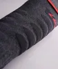 A close-up view of a dark gray sock with red accents and ribbed detailing. Produktbild-Vorschau