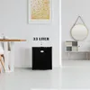 A mini-refrigerator is shown in a modern room setting, next to a dining table and a cabinet with a mirror. Náhľad obrázku produktu